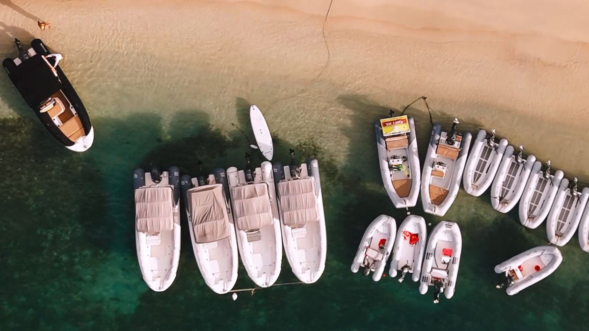 Aerial view of Wharfside Watersports' dinghy, Zodiac, and Medline rental boats lined up at the beach in Cruz Bay, St. John USVI