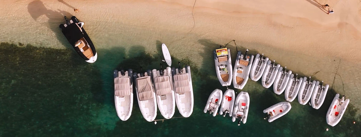 Aerial view of Wharfside Watersports' dinghy, Zodiac, and Medline rental boats lined up at the beach in Cruz Bay, St. John USVI